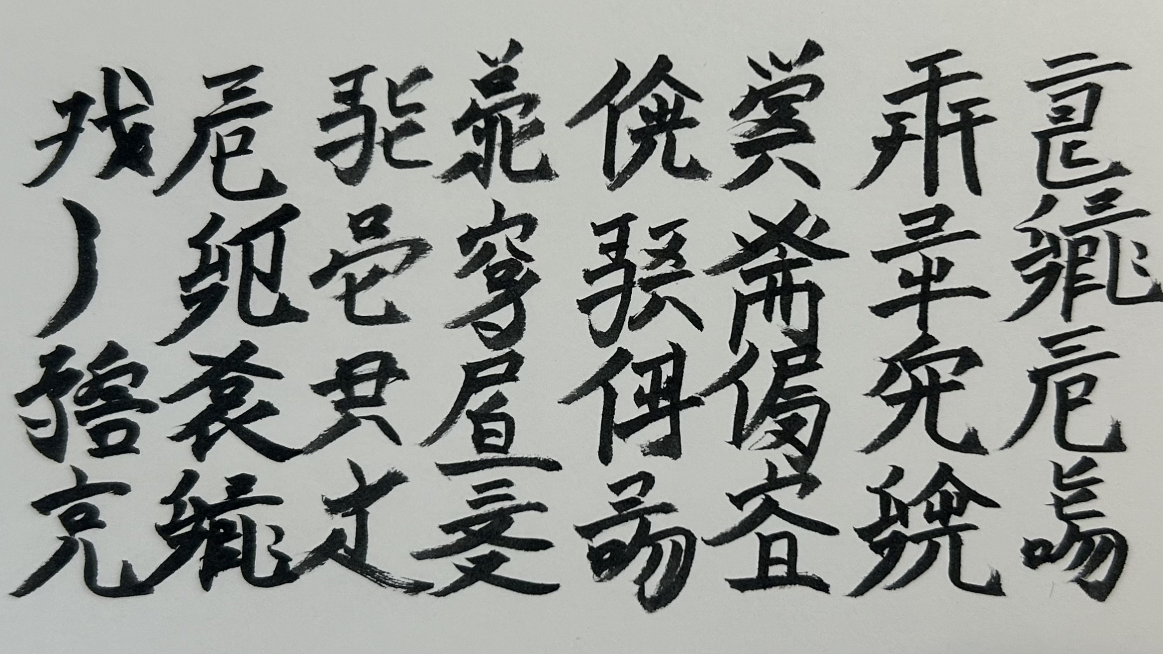筆で縦書きした、4字8行の留為語の詩